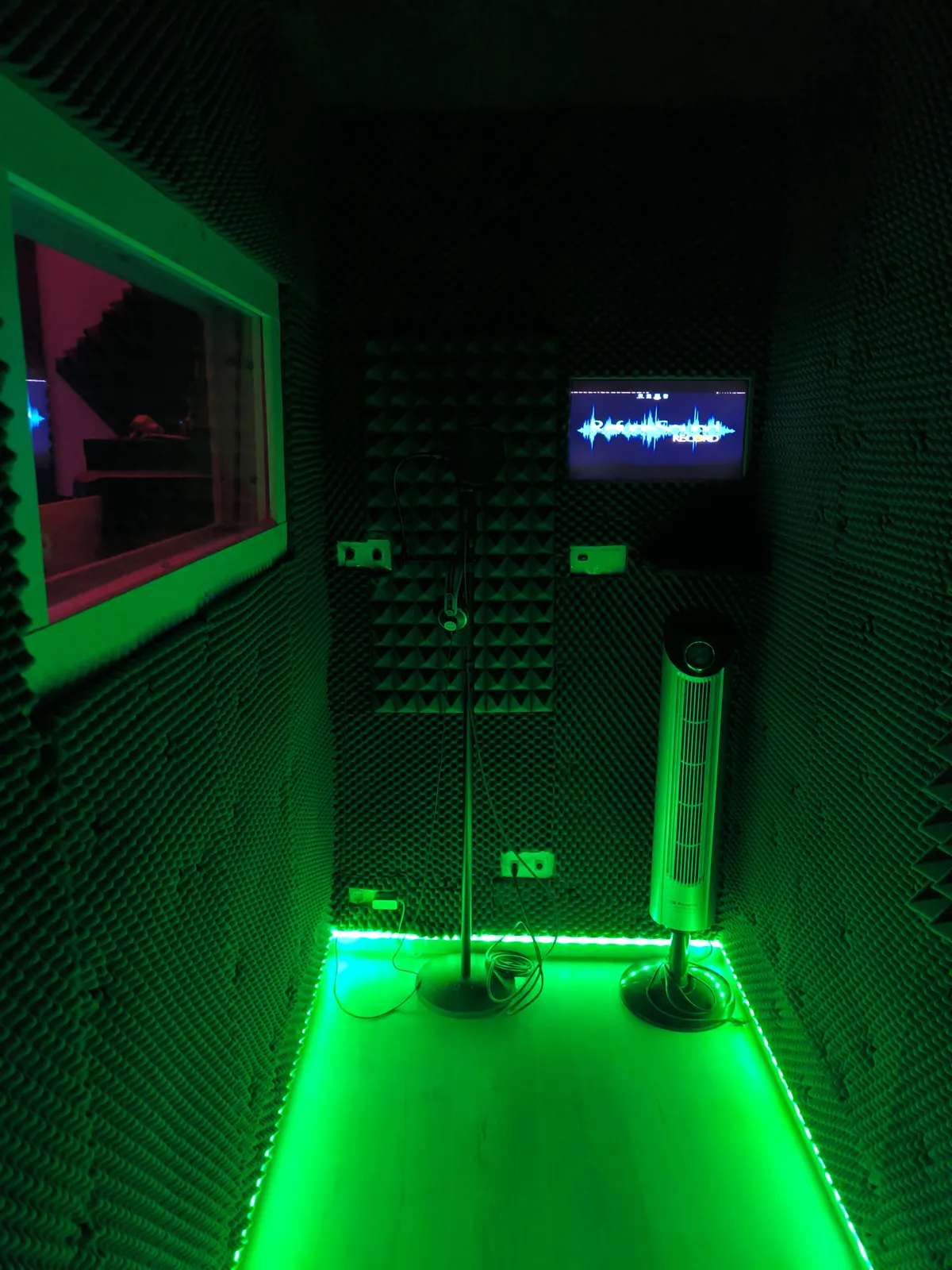 Cabina de voces con luz verde y micrófono