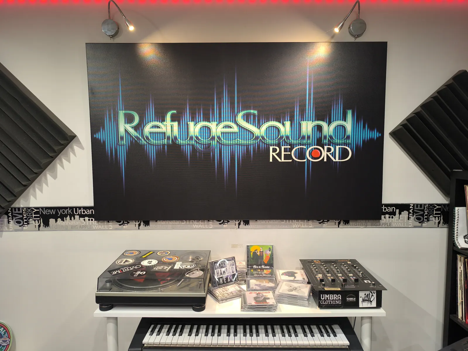 Cuadro de Refuge Sound Record sobre el tocadiscos y discos