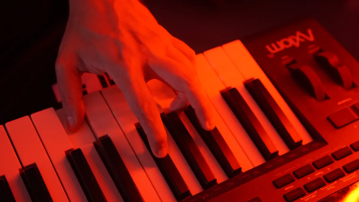 Manos sobre el teclado bajo la luz roja del estudio